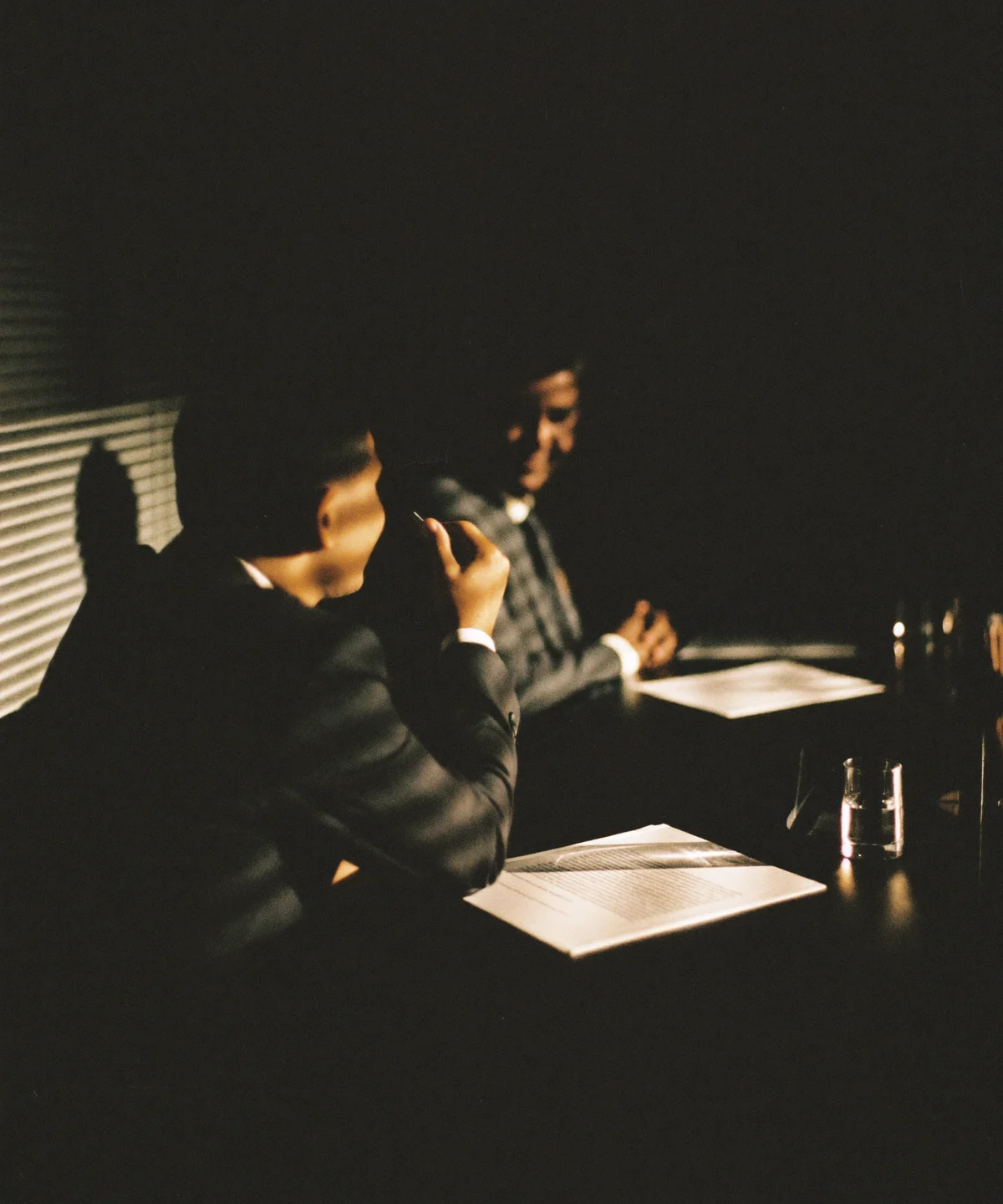 Reunião executiva em sala de reuniões com iluminação baixa